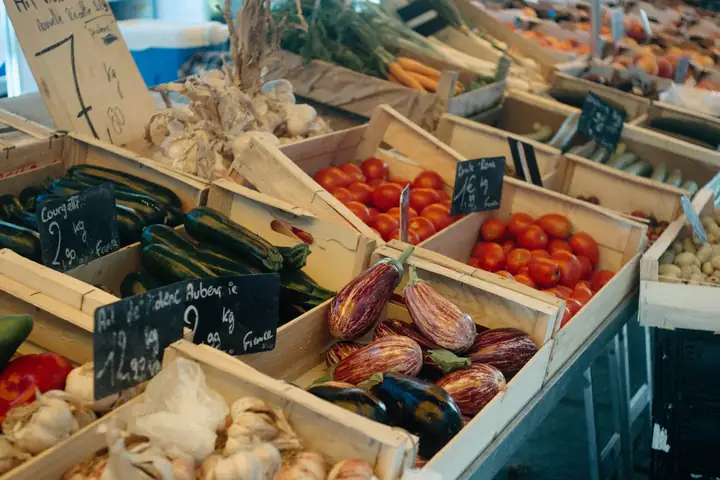 Tomatoes, squash and onions in wooden crates.